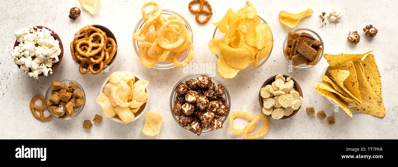 Assortment of Unhealthy Snacks chips, popcorn, nachos, pretzels, onion