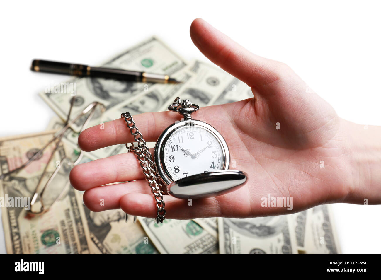 Silver pocket clock in hand on money background. Time is money concept ...