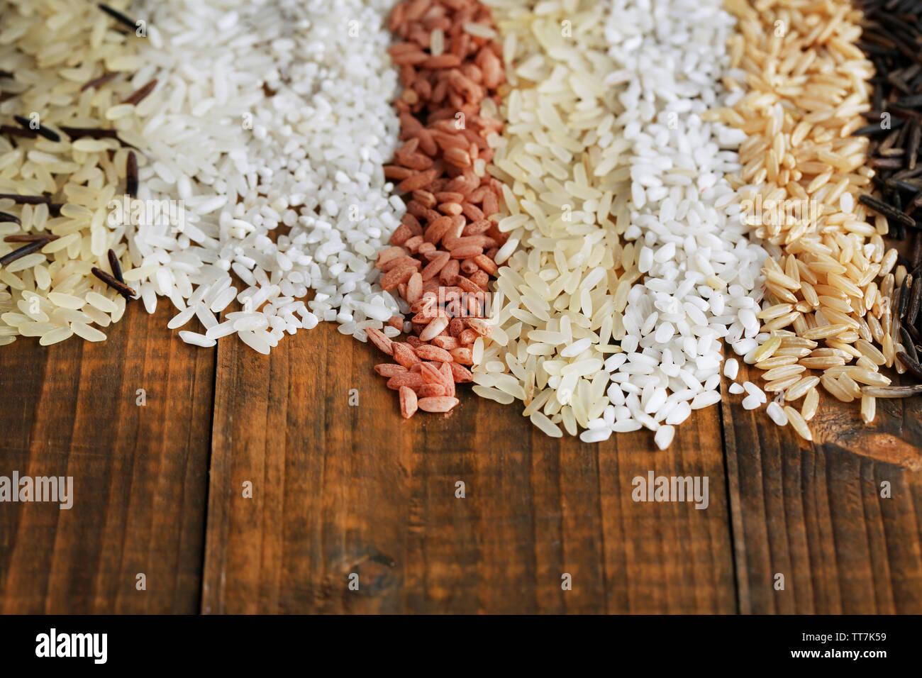 Different types of rice on wooden background Stock Photo - Alamy
