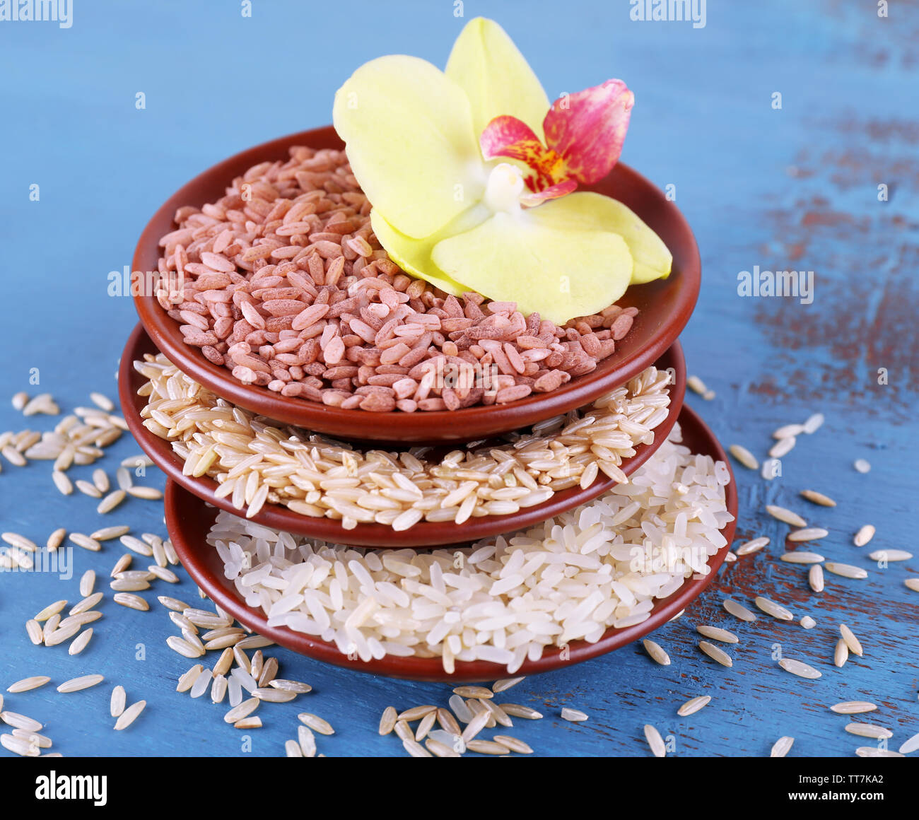 Different types of rice in bowls on wooden background Stock Photo Alamy