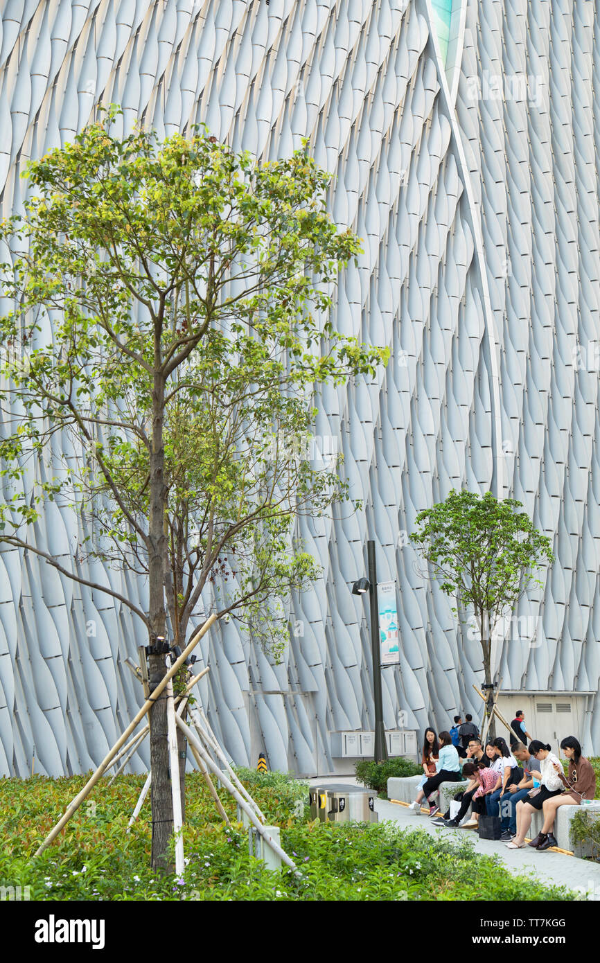 People sitting outside Xiqu Centre, Kowloon, Hong Kong Stock Photo