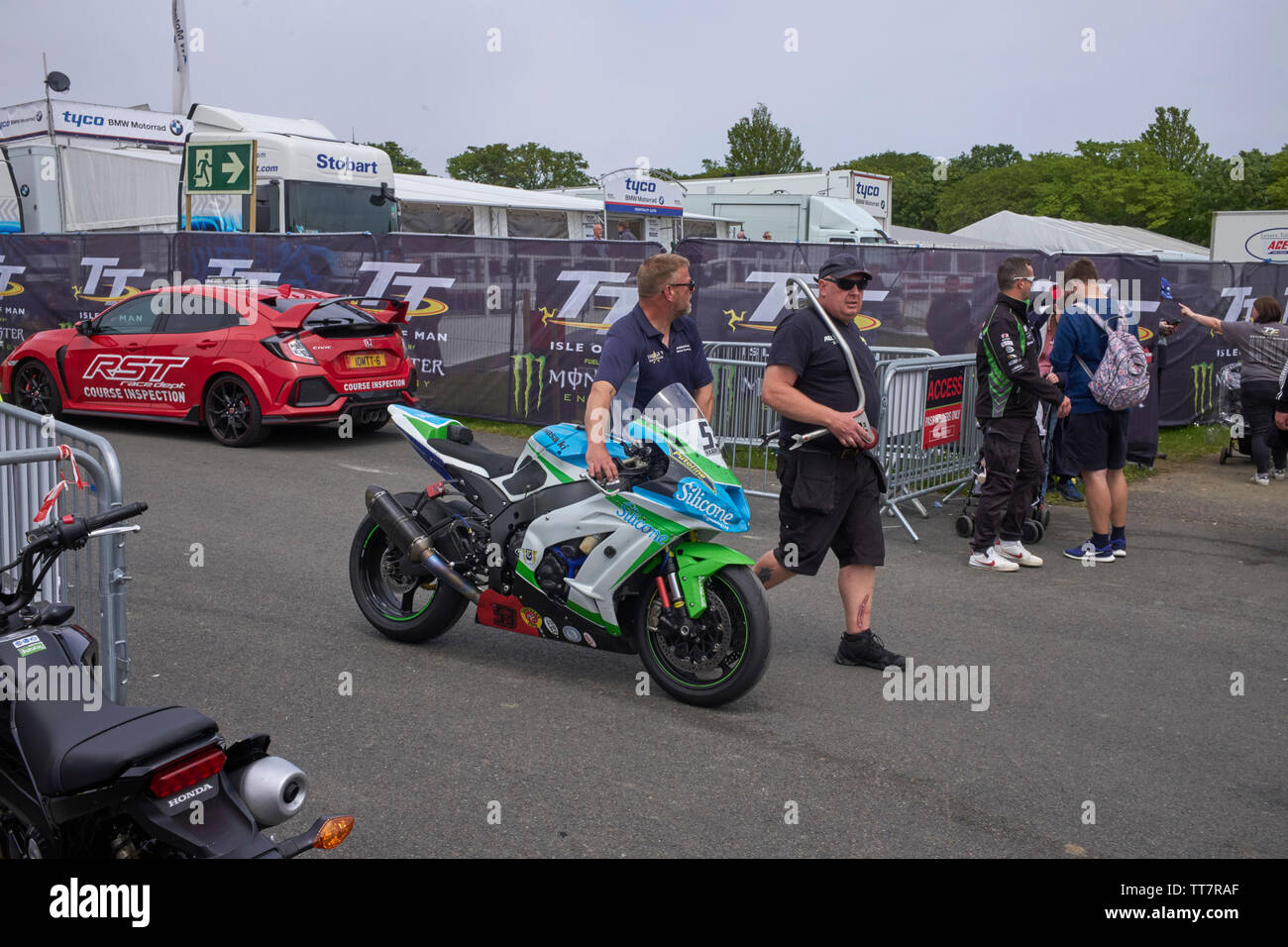 Members of Adrian Harrison’s team wheel back his 1000 Kawasaki bike after the 2019 Senior TT race Stock Photo