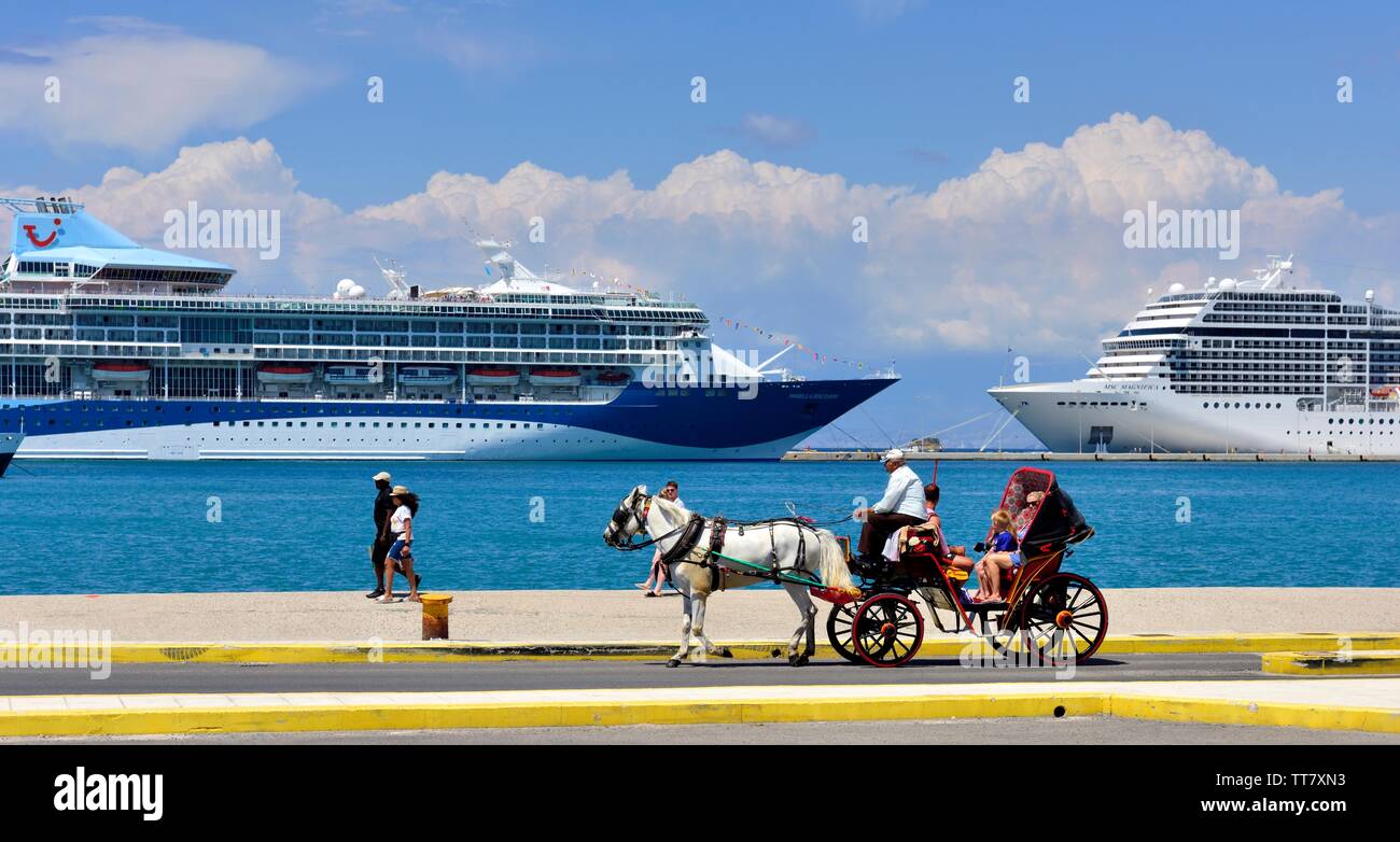 Tourists riding a horse drawn carriage,into Corfu Port,with cruise ships in the background,Kerkyra,Greek ionian islands,Greece Stock Photo