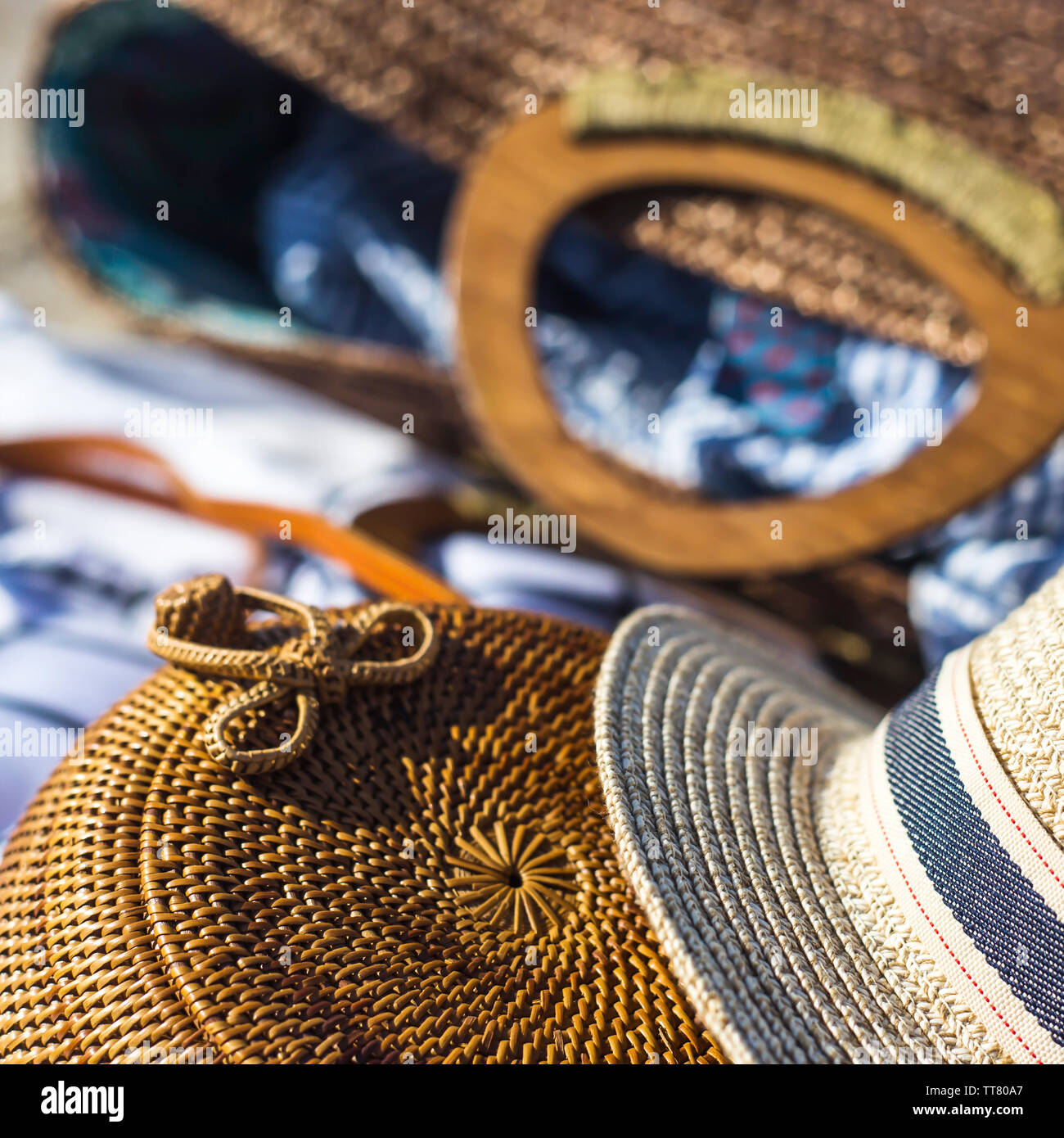Straw hat and bag on a white bed which lies on the sand on the beach ...