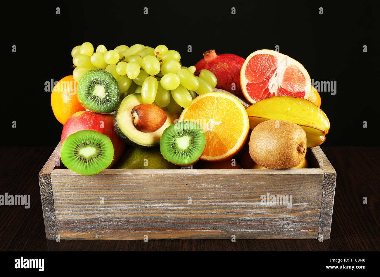 Assortment of fruits in box on black background Stock Photo - Alamy