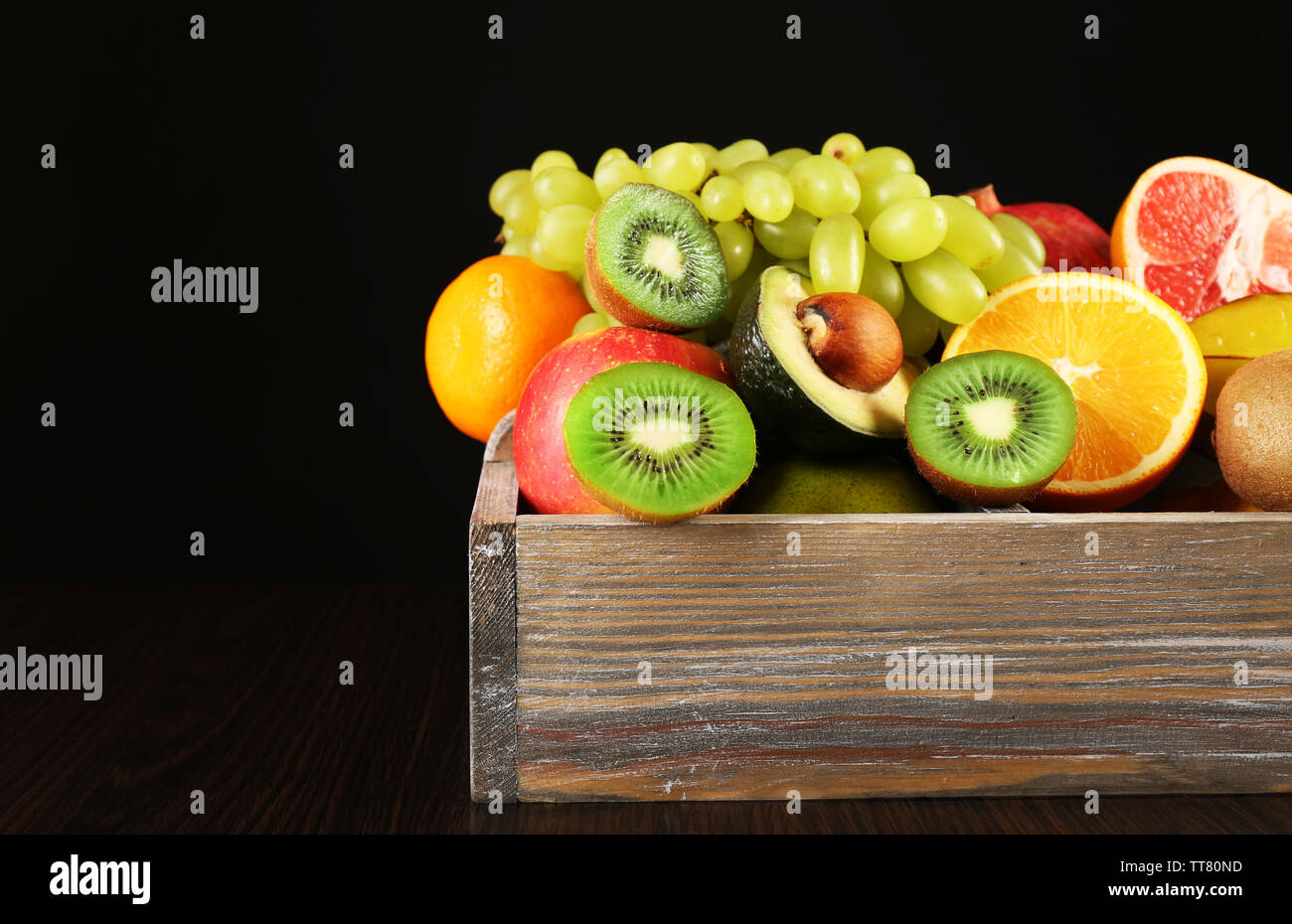 Assortment of fruits in box on black background Stock Photo - Alamy