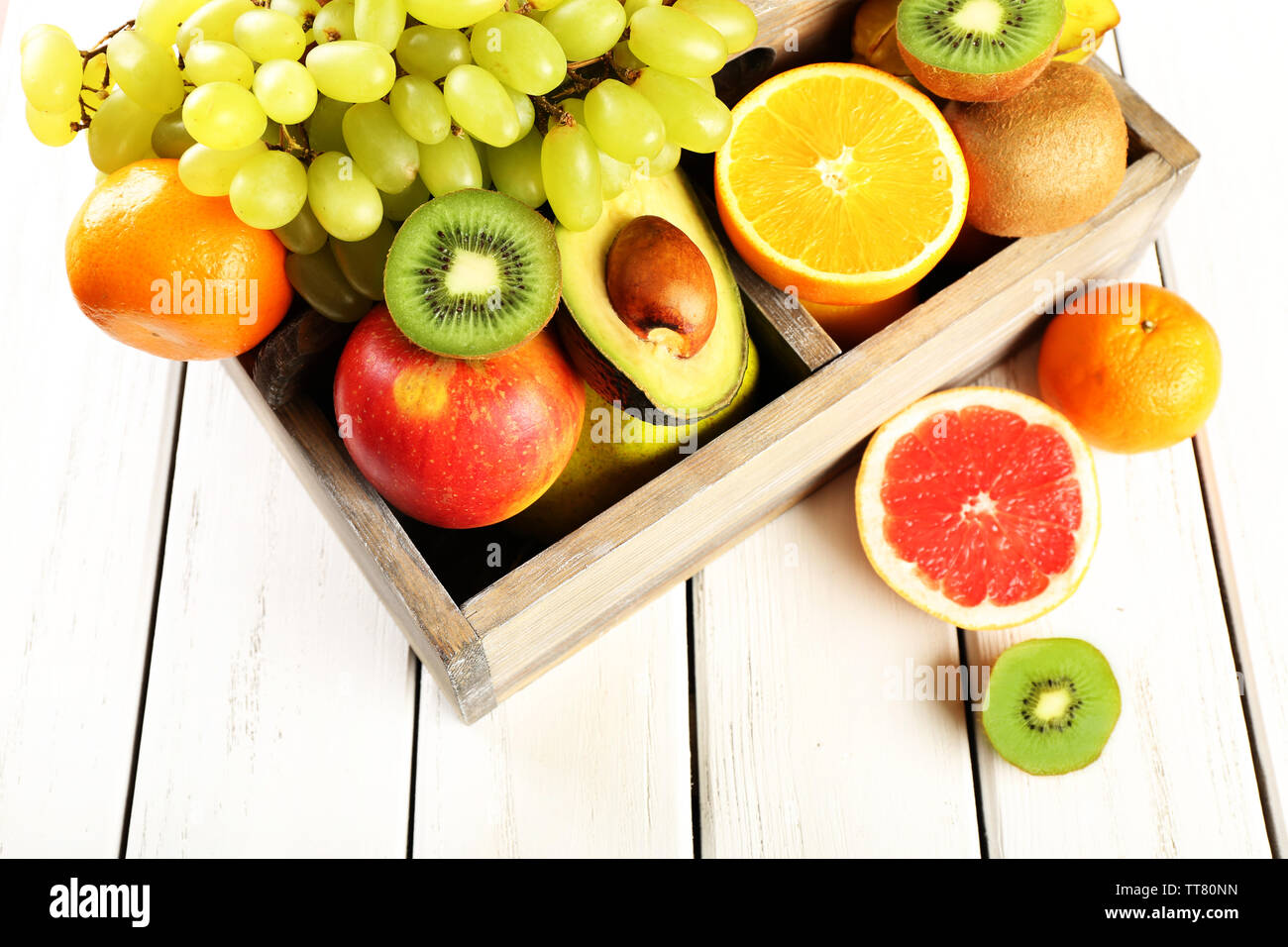 Assortment of fruits in box on wooden table Stock Photo - Alamy