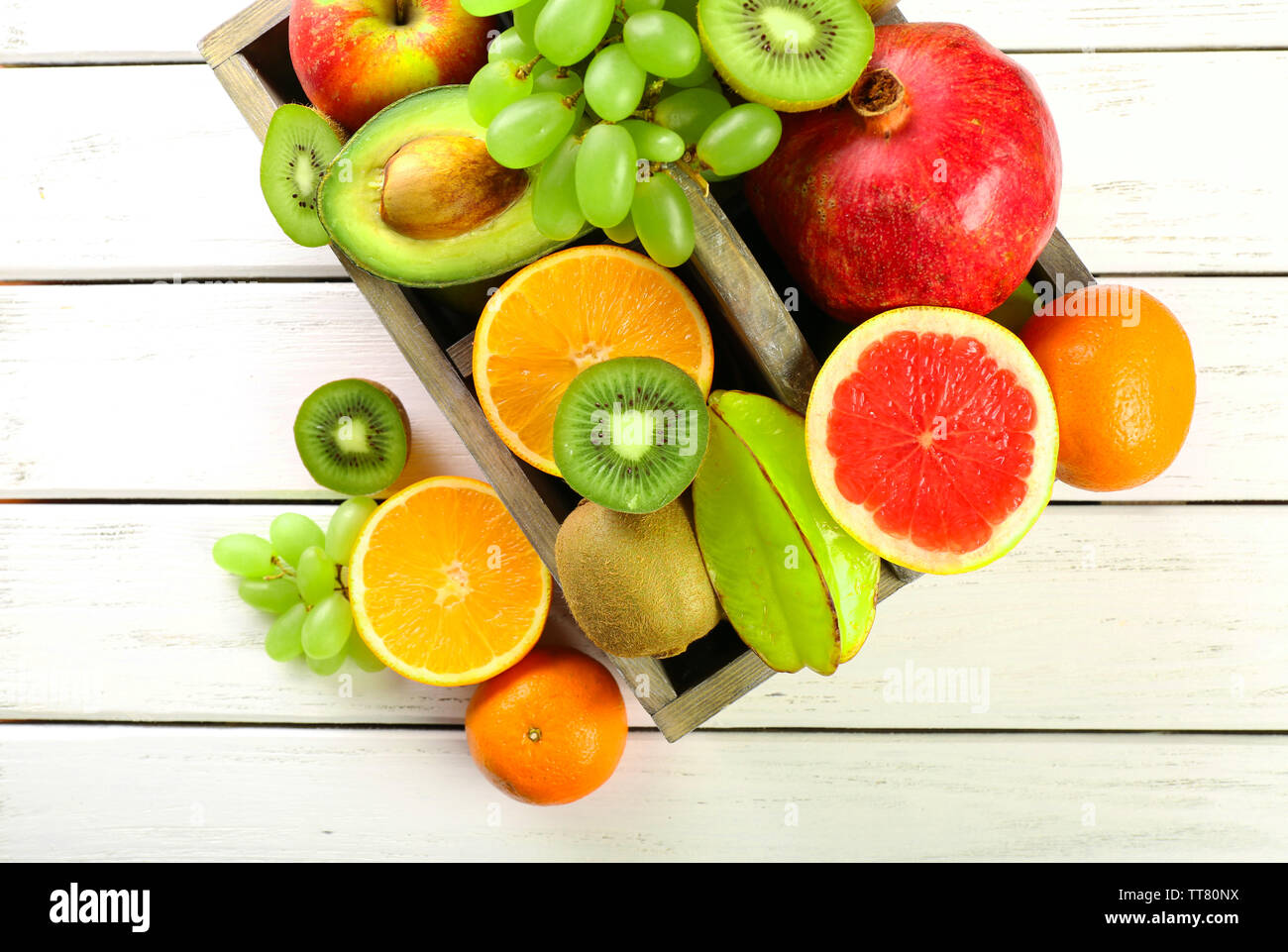 Assortment of fruits in box on wooden table Stock Photo - Alamy