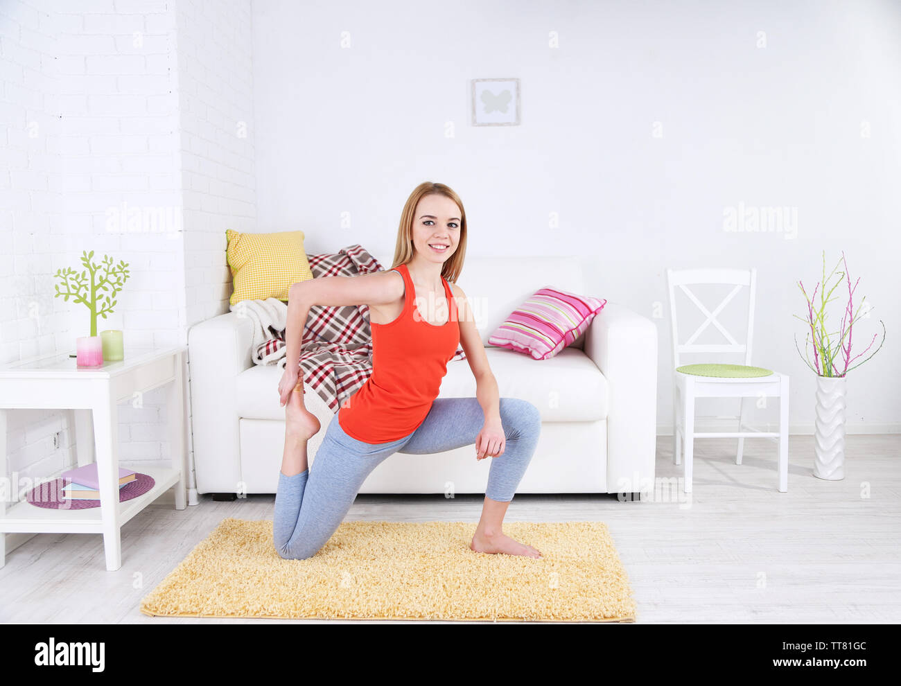Young woman doing yoga at home Stock Photo - Alamy