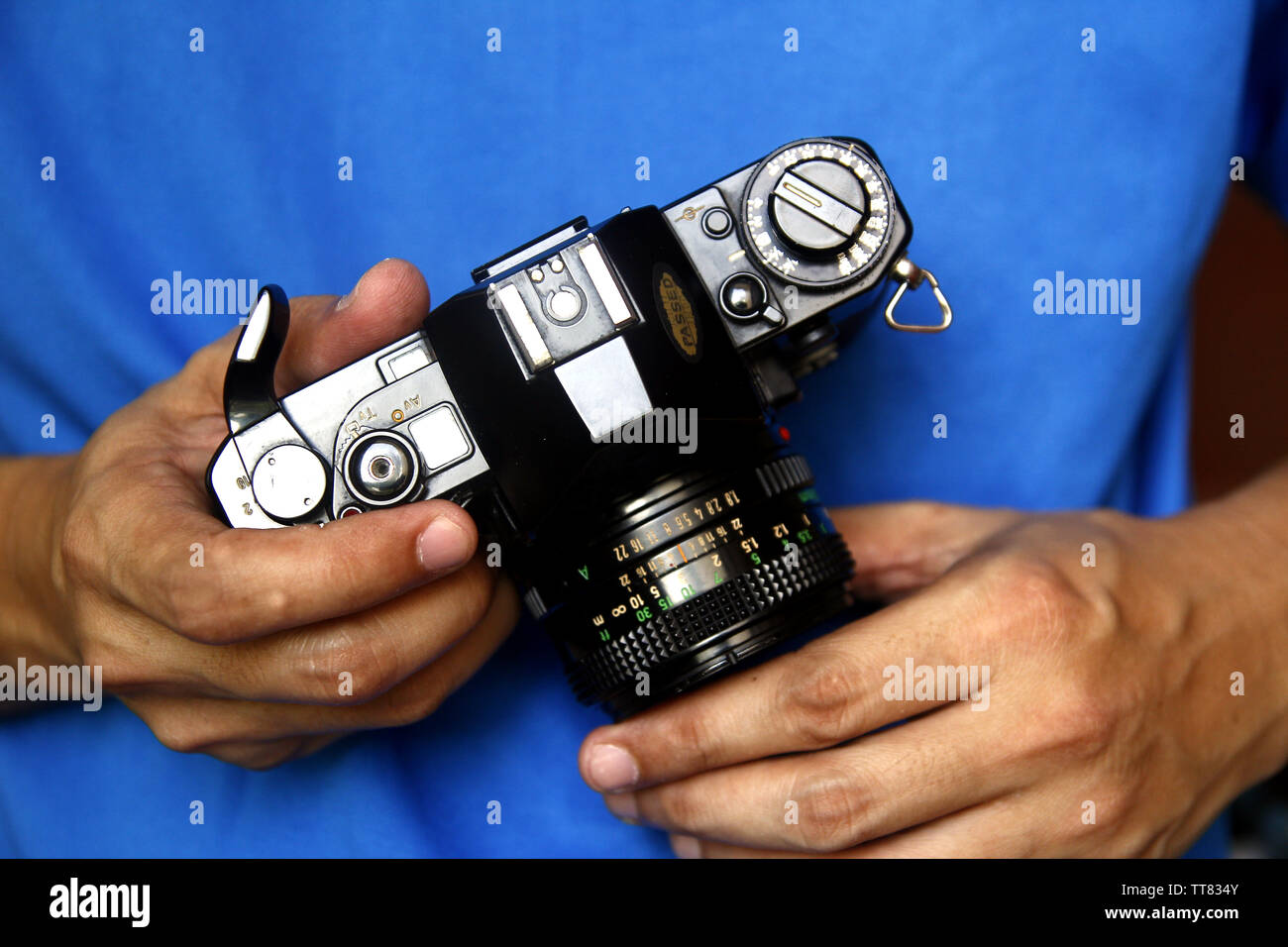 Close up photo of a pair of a man’s hands holding a 35mm manual film