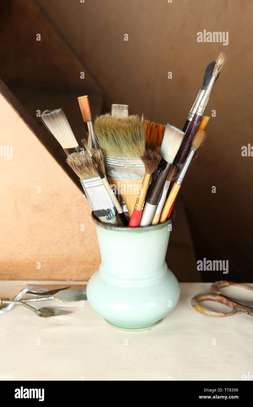 Paintbrushes In Vase On Wooden Background Stock Photo 255875122