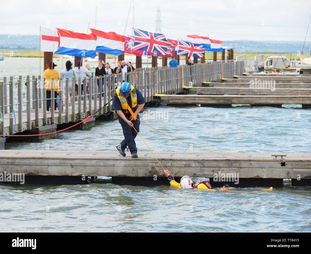 Queenborough, Kent, UK. 15th June, 2019. Sheerness RNLI held an Open Day in Queenborough Habour, Kent this day with various demonstrations. A volunteer is rescued from the water using a throw line from a Coastguard officer. Credit: James Bell/Alamy Live News Stock Photo
