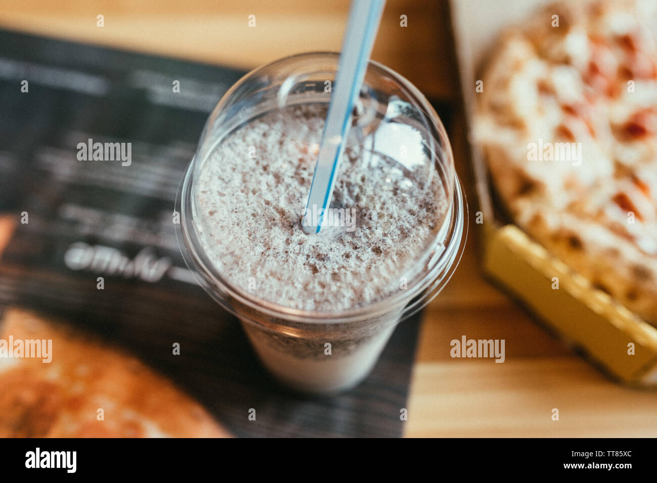 https://c8.alamy.com/comp/TT85XC/a-plastic-cup-with-a-straw-with-milkshake-and-cookies-inside-TT85XC.jpg