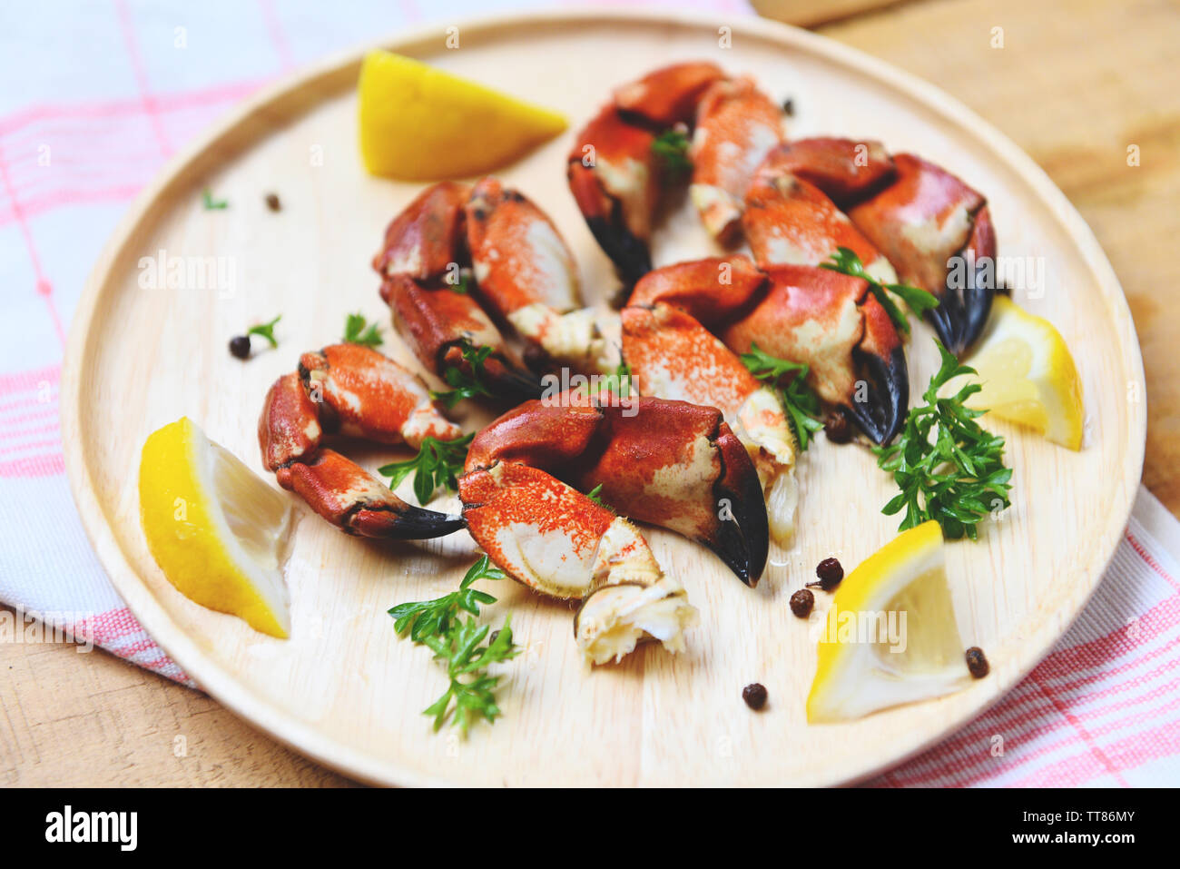 Red stone crab claw / Cooked crabs boiled on wooden plate with lemon on plate served seafood