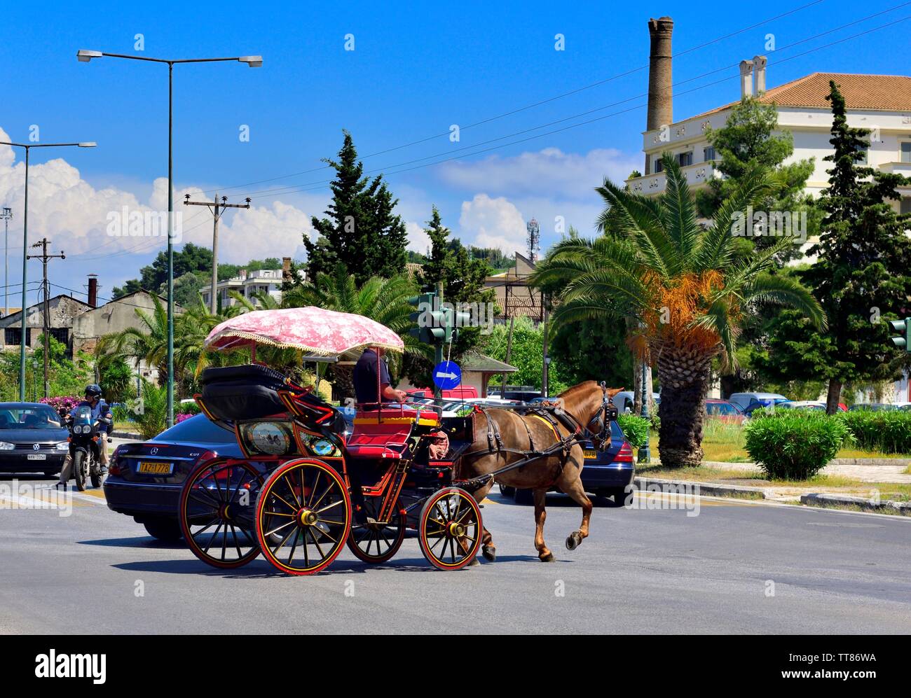 Tourists riding a horse drawn carriage,into Corfu town,with road traffic,Kerkyra,Greek ionian islands,Greece Stock Photo