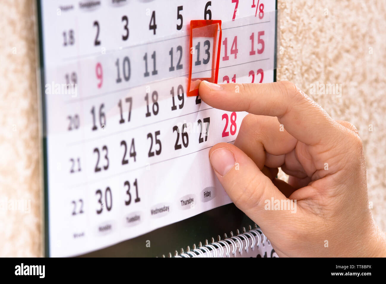 woman hand placing red mark on calendar date, closeup Stock Photo