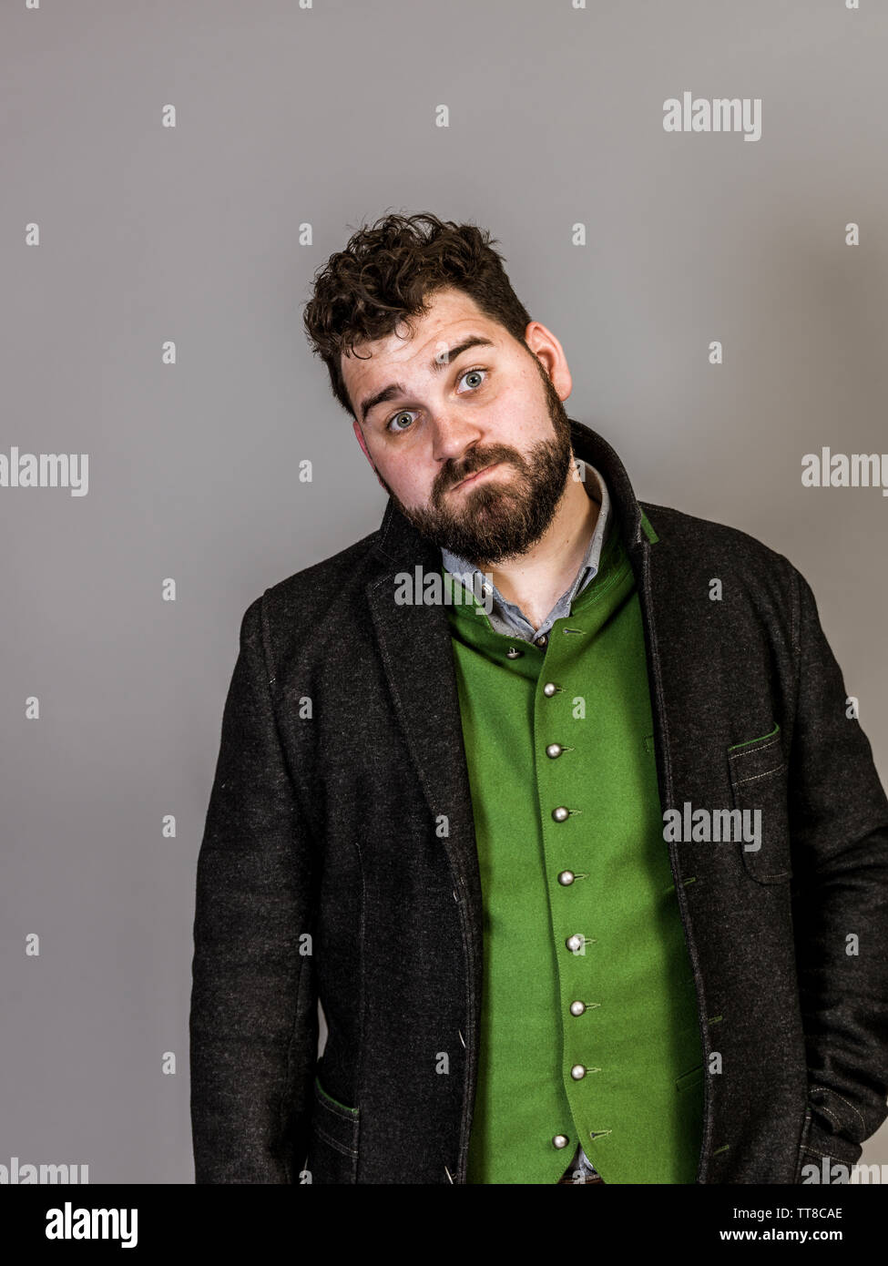 cool man with traditional costume is posing in front of grey background Stock Photo