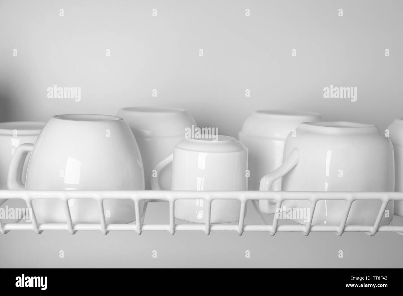 Clean cups drying on metal dish rack close up Stock Photo Alamy