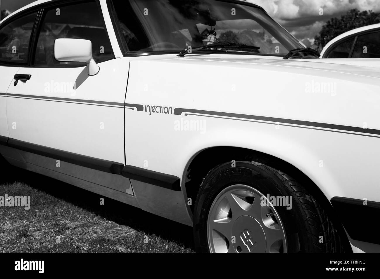 Front wing and door panel of a classic Ford Capri 2.8i shwoing side stripes and 'injection' logo in monochrome. Stock Photo