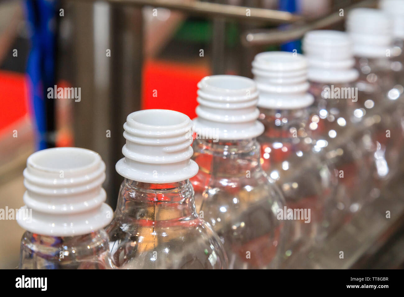 transparent plastic bottles on the conveyor belt move into water filling machine in the drinking water factory. beverage industry. Stock Photo