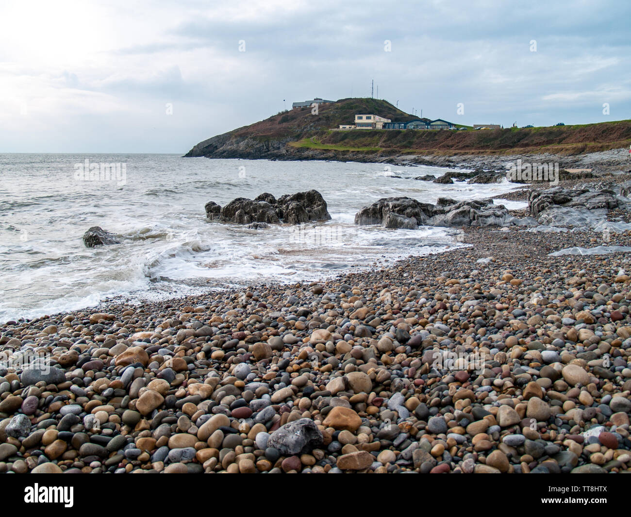 A view from Bracelet Bay towards the old coastguard station with views across the sea to the coast of north Devon. Swansea, Gower, Wales, UK. Stock Photo