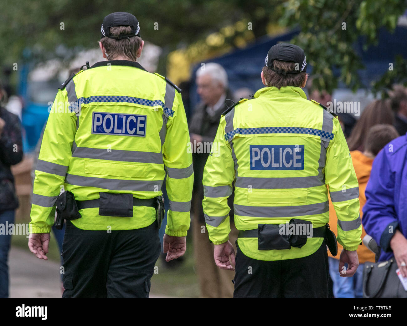 Two male British police officers in hi viz jackets patrol the park grounds during the Leyland Festival 2019 Stock Photo