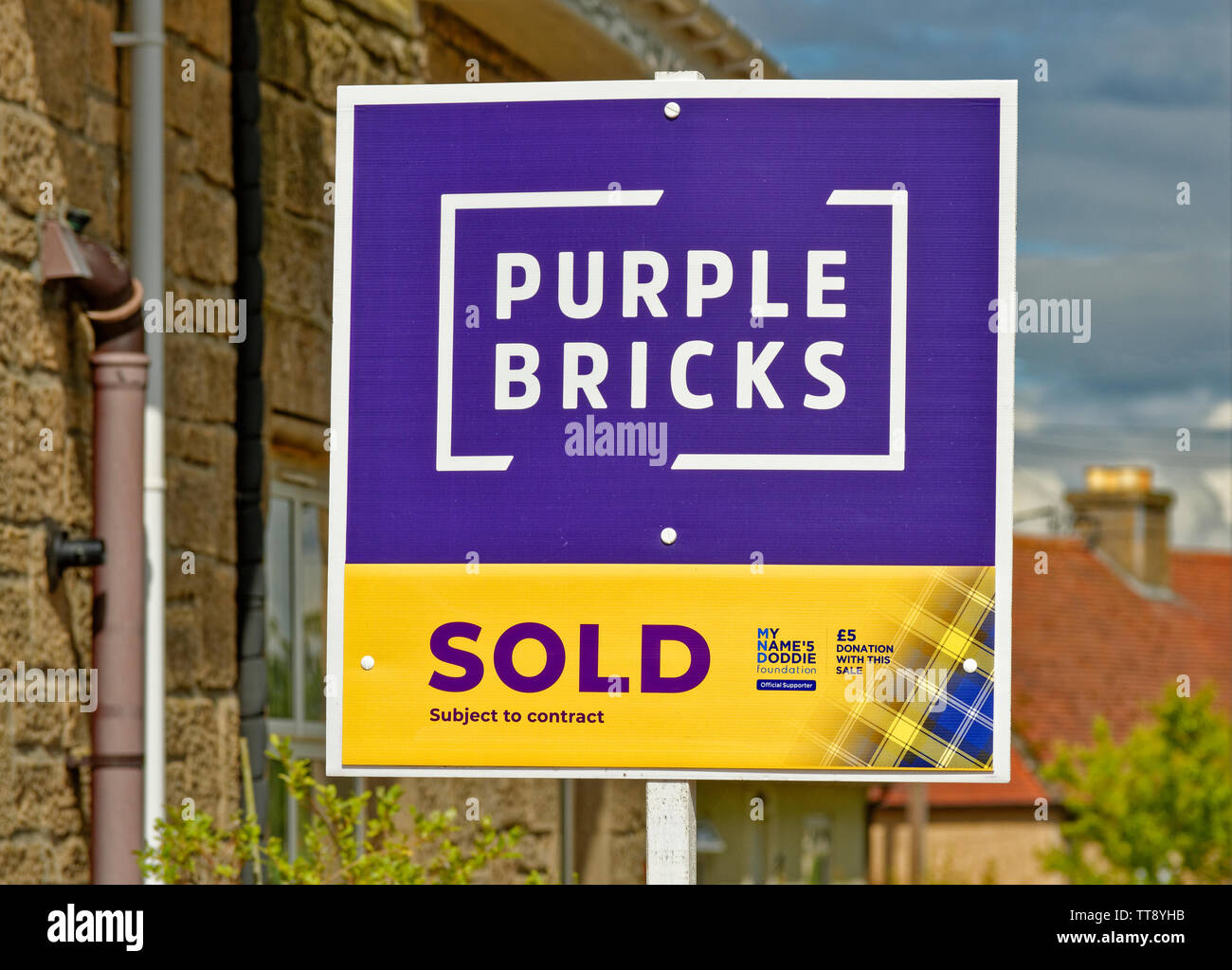 PURPLE BRICKS ON LINE ESTATE AGENCY SOLD SUBJECT TO CONTRACT SIGN OUTSIDE A HOUSE Stock Photo