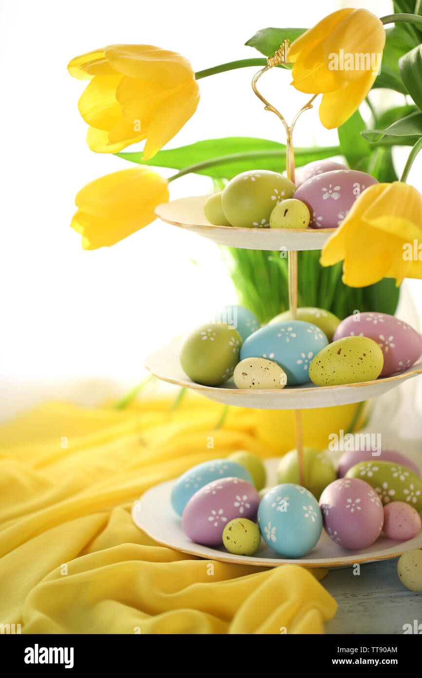 Easter eggs on vase and tulips on table on bright background Stock ...