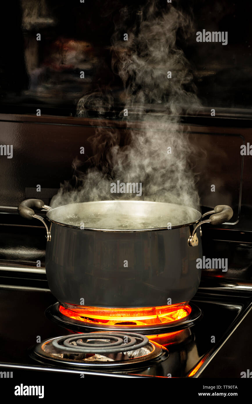 https://c8.alamy.com/comp/TT90TA/vertical-shot-of-watering-boiling-in-a-dutch-oven-on-a-stove-top-with-a-glowing-red-element-TT90TA.jpg