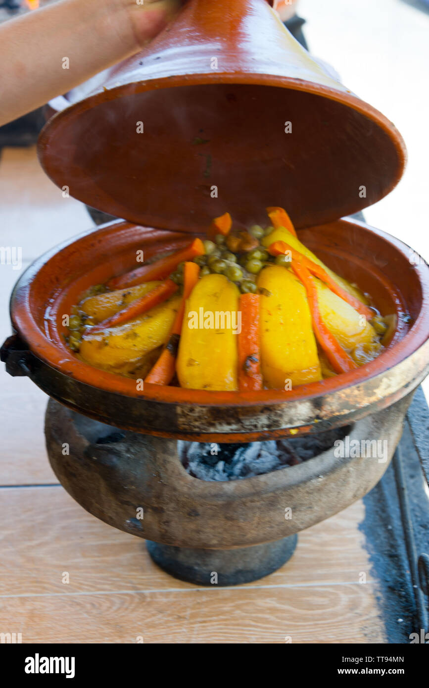 Cooking In Traditional Moroccan Tajine Pot Over Open Fire Stock Photo