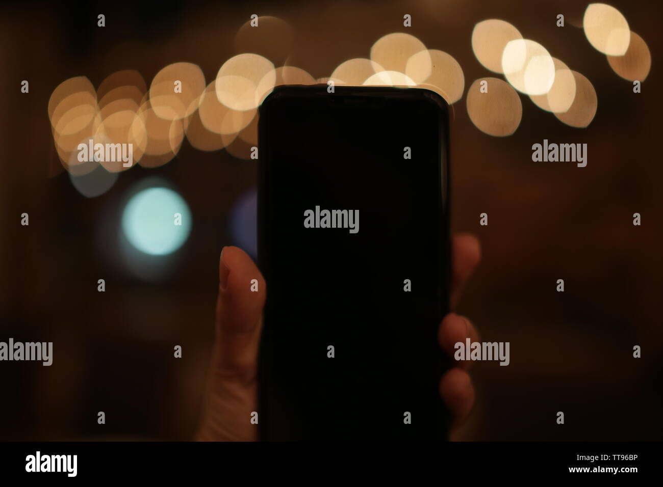 bokeh lights with hand holding smart phone blank screen Stock Photo - Alamy
