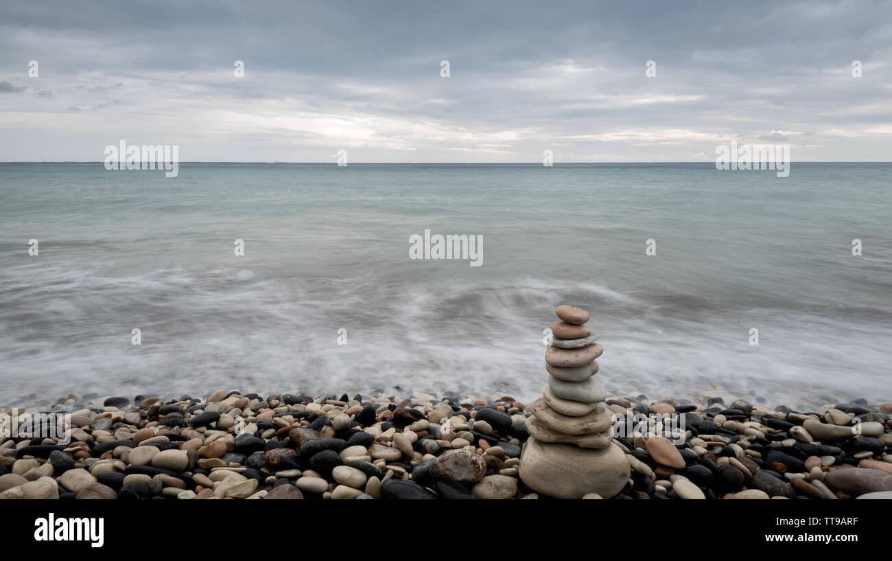 Pyramid of balancing pebbles, in the ocean Stock Photo