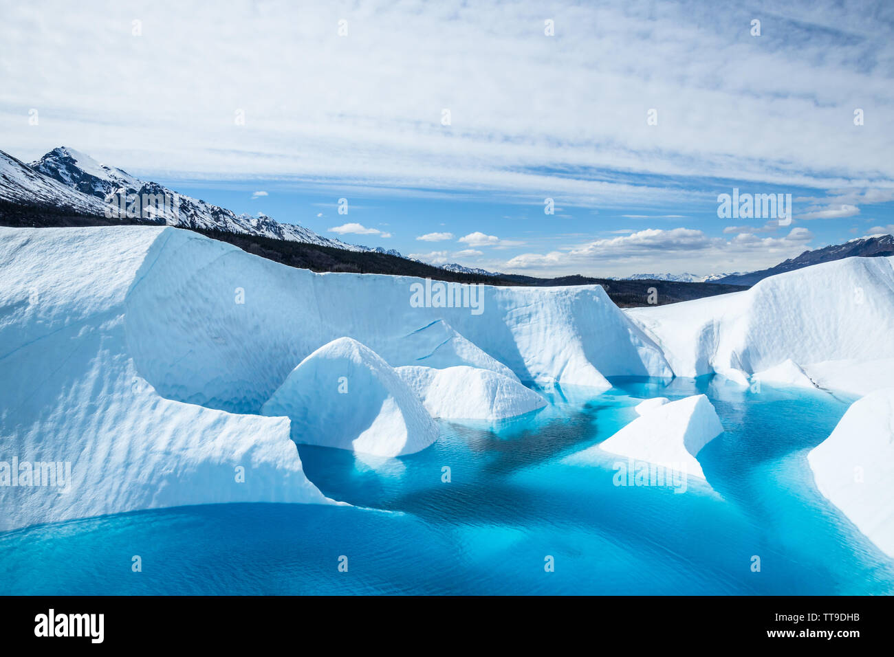 A lake sits on top of the Matanuska Glacier in south central Alaska. The ater is a deep crystal blue from minerals of the melting ice. Stock Photo