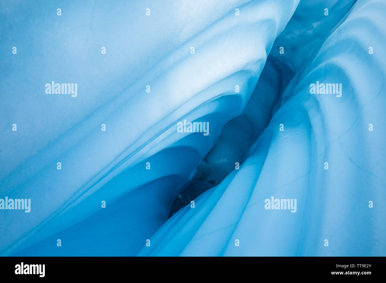 In the Matanuska Glacier, a narrow canyon is cut through the ice by melting water from above. Stock Photo