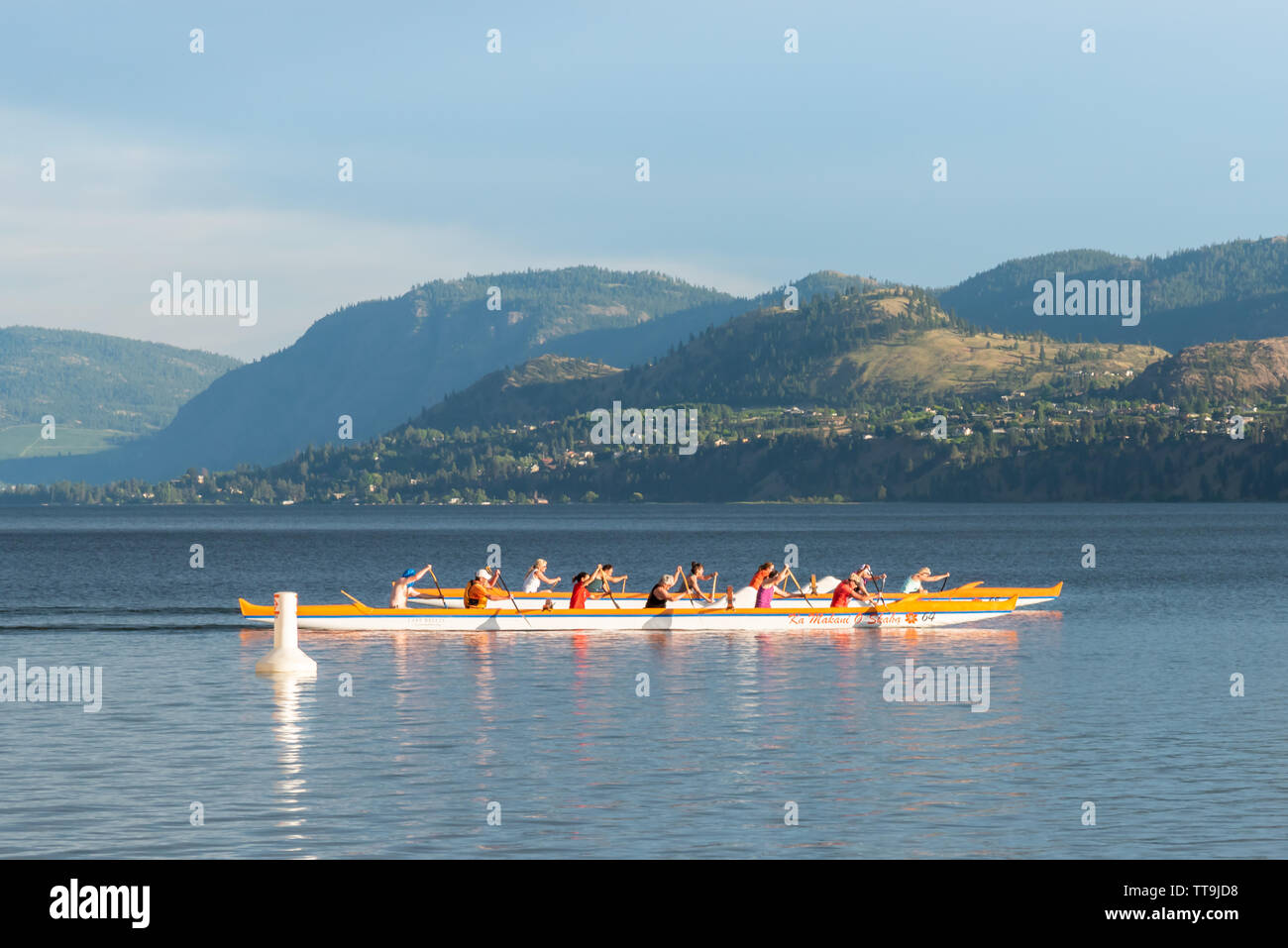 Closeup of teams rowing dragon boats across Skaha Lake. Penticton