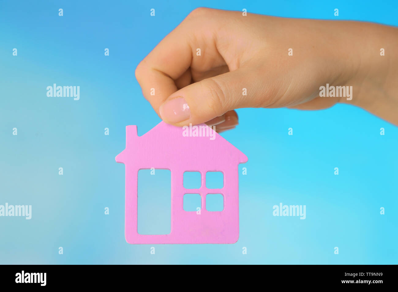 Female hand with model of house on color background Stock Photo - Alamy