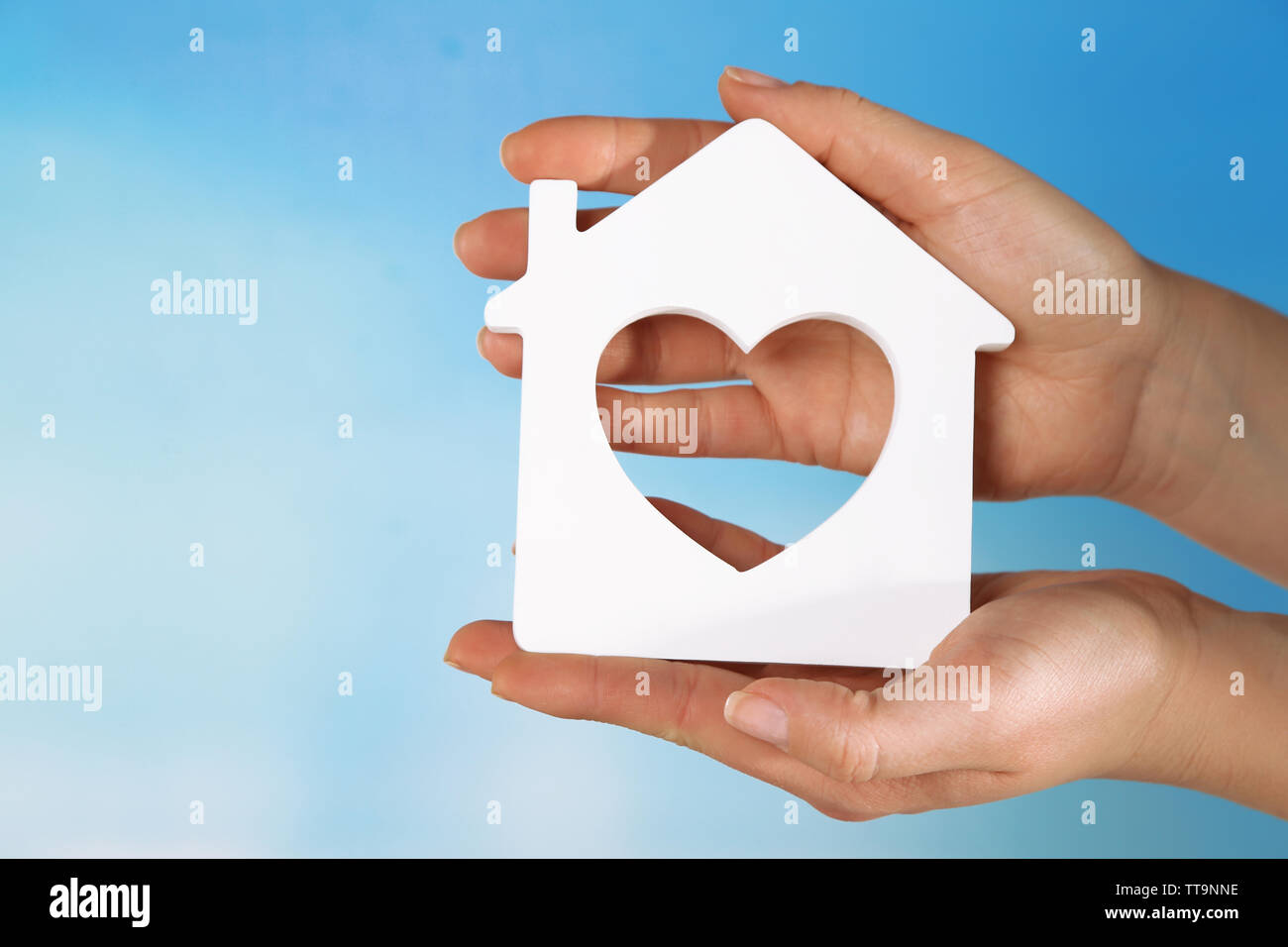 Female hands with model of house on color background Stock Photo - Alamy