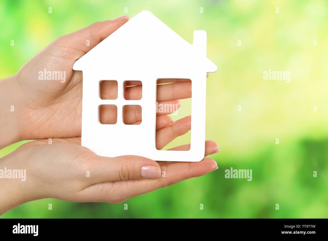 Female hands holding model of house on bright background Stock Photo ...