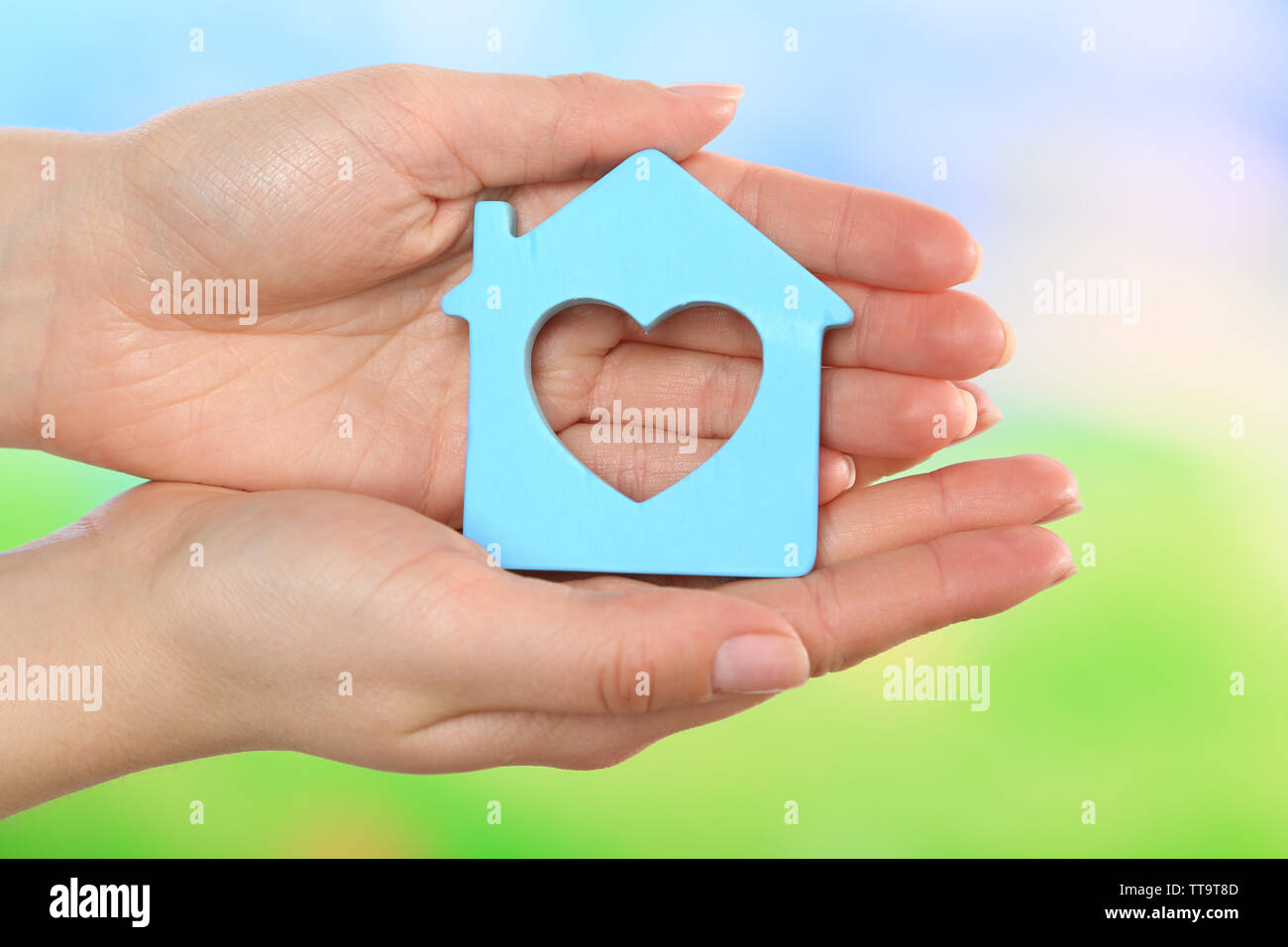 Female hands holding model of house on bright background Stock Photo ...