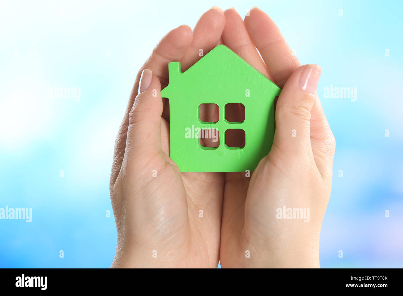 Female hands holding model of house on bright background Stock Photo ...