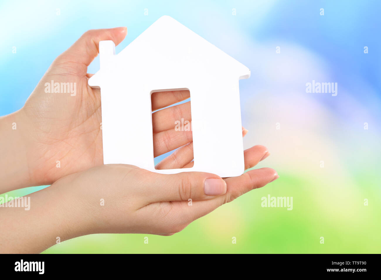 Female hands holding model of house on bright background Stock Photo ...