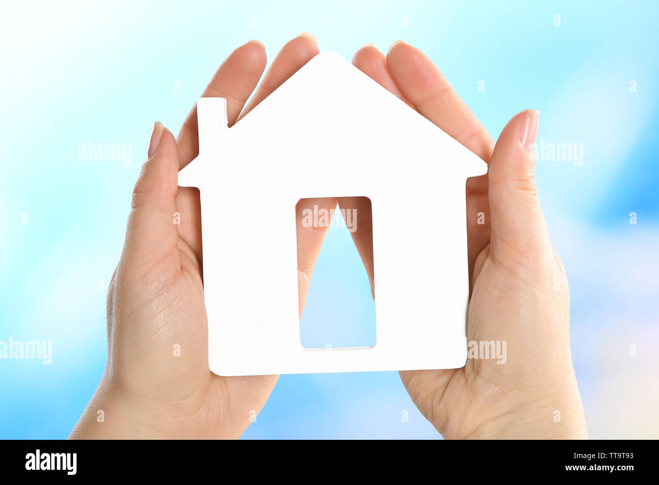 Female hands holding model of house on bright background Stock Photo ...