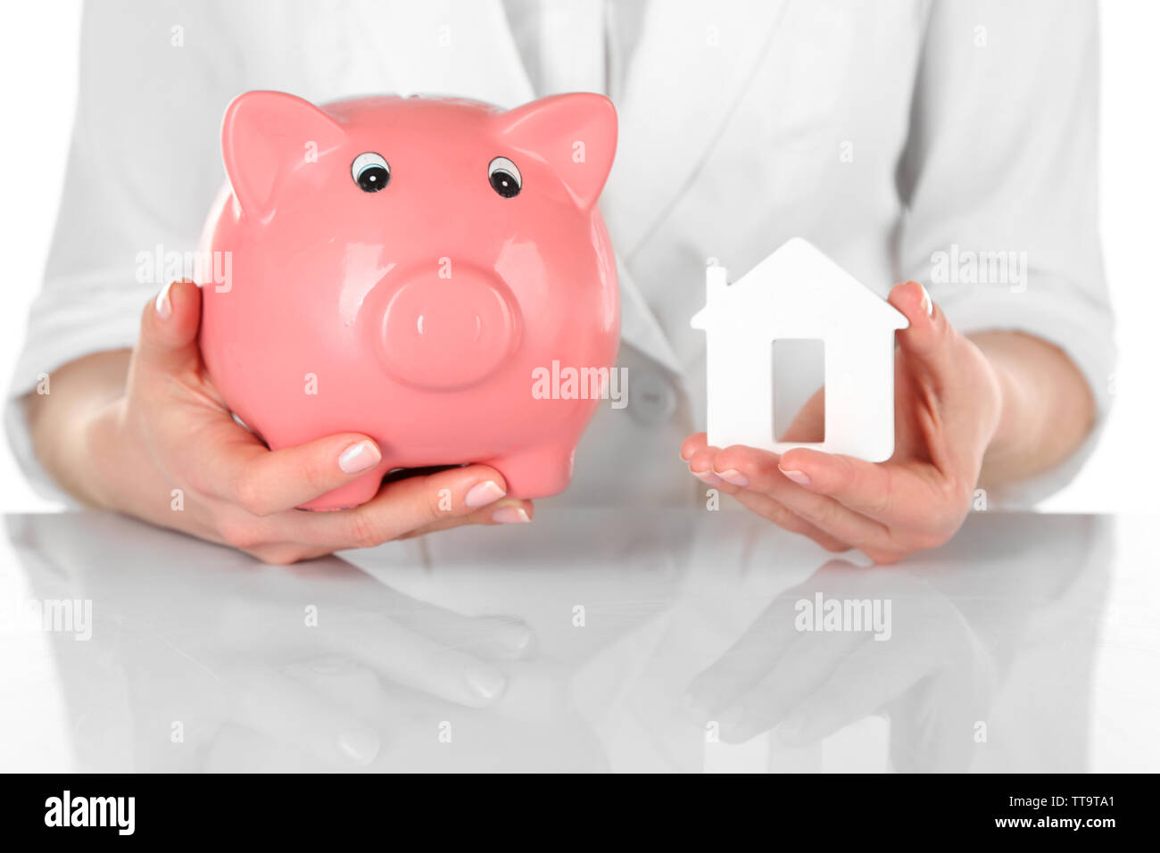 Woman holding model of house and piggy bank close up Stock Photo - Alamy