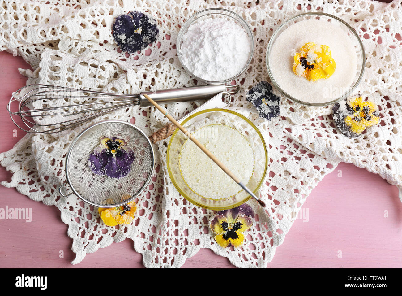Making candied violet flowers with egg whites and sugar, on color