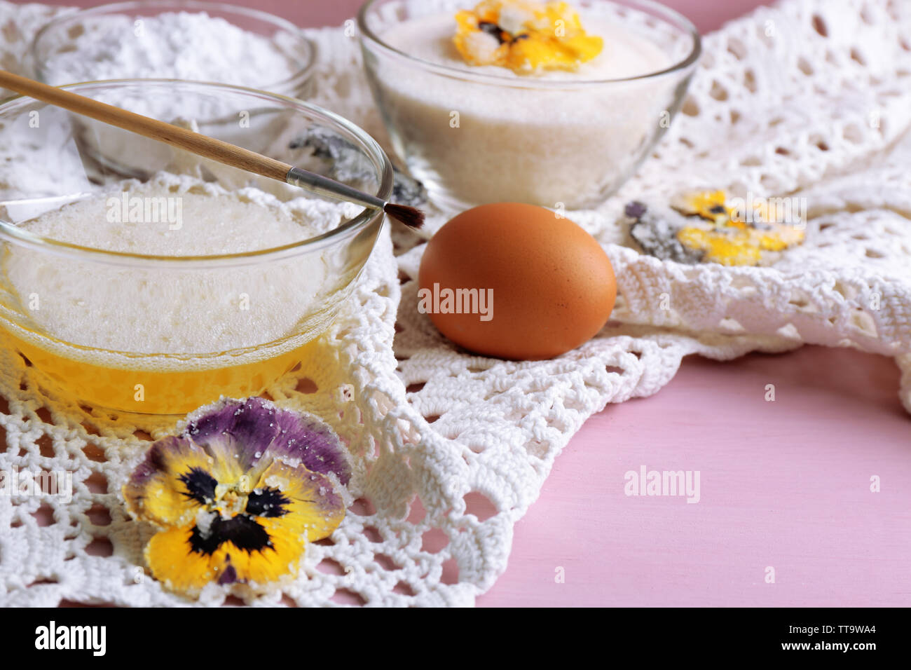 Making candied violet flowers with egg whites and sugar, on color