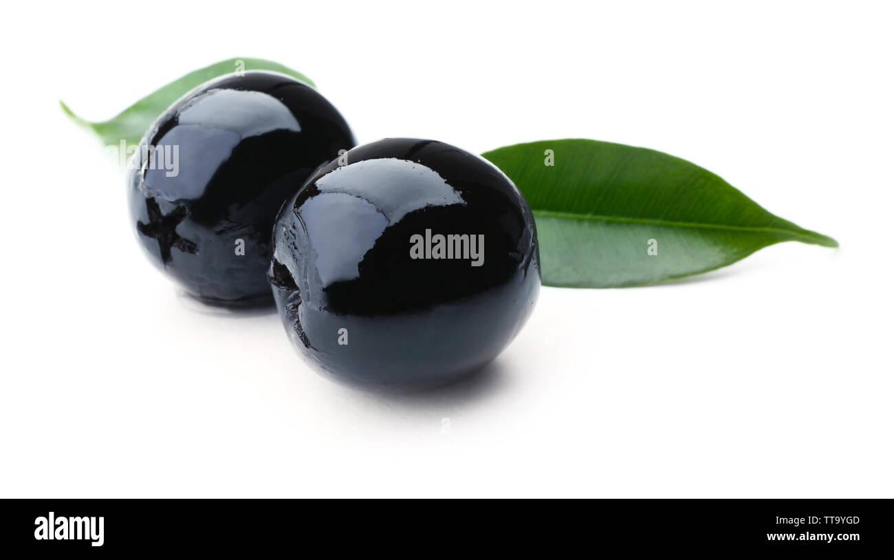 Black olives with green leaves isolated on white Stock Photo - Alamy