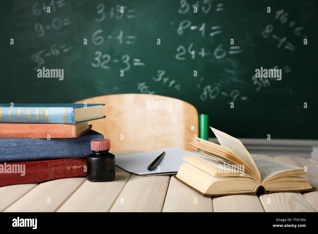 Teachers workplace on blackboard background Stock Photo - Alamy