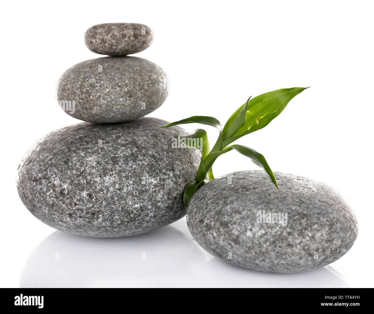 Stack of spa stones with green leaves isolated on white Stock Photo - Alamy