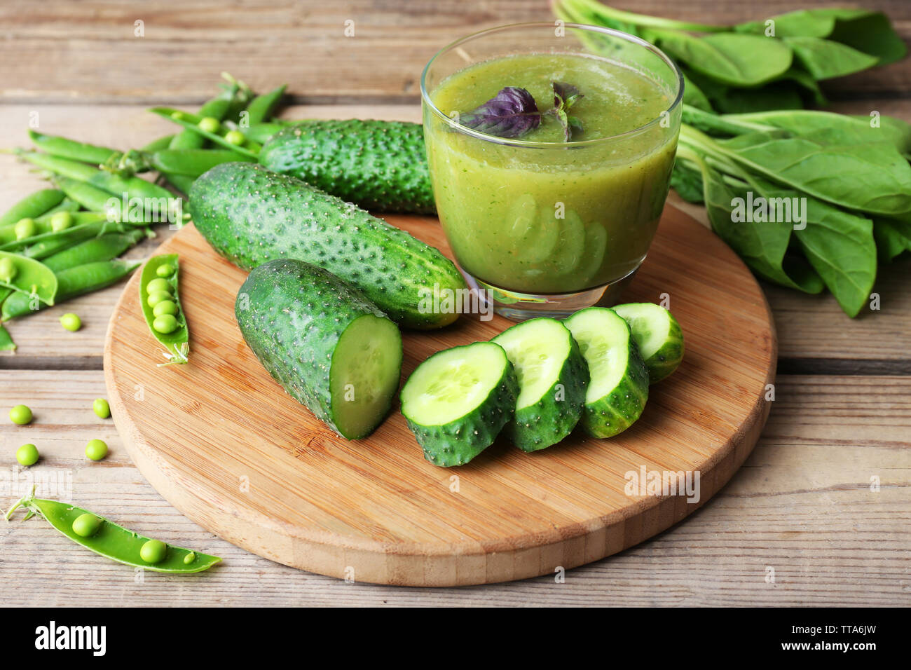 Glass of green healthy juice with spinach and cucumbers on table close ...