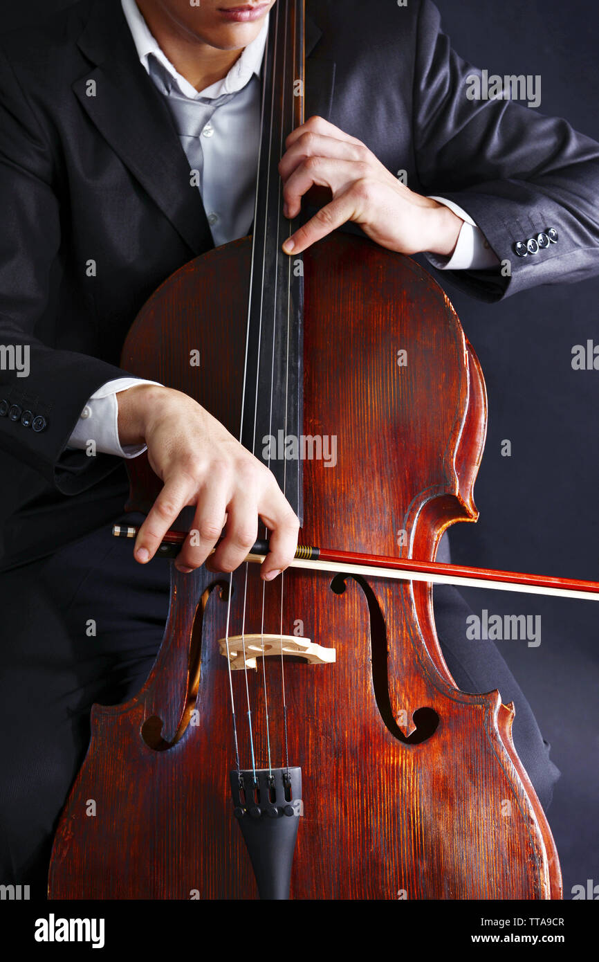 Man playing on cello on dark background Stock Photo